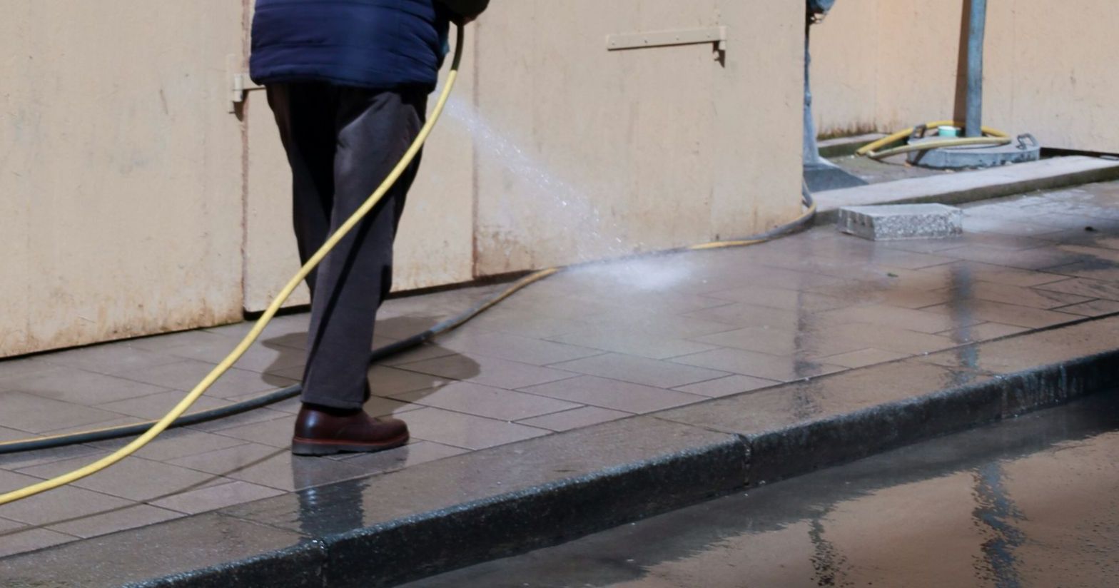 a man is using a hose to clean the street